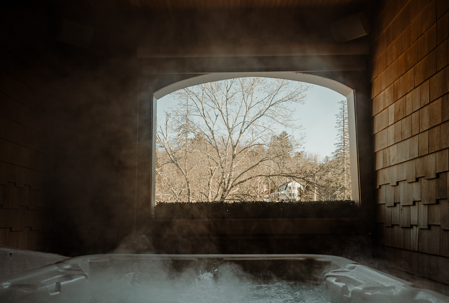 A hot tub with steam coming out of it in front of a window at the Wentworth