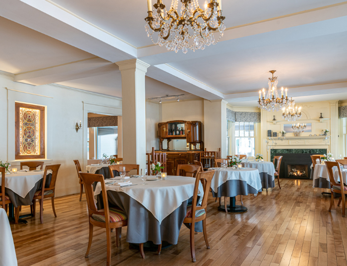 1869 room with tables, chairs, and chandeliers at the Wentworth.