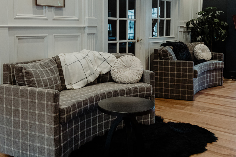 Two couches with a black round table and black fur rug.