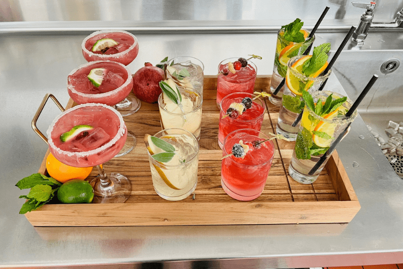 A wooden tray of drinks with fruits and ice at the Wentworth