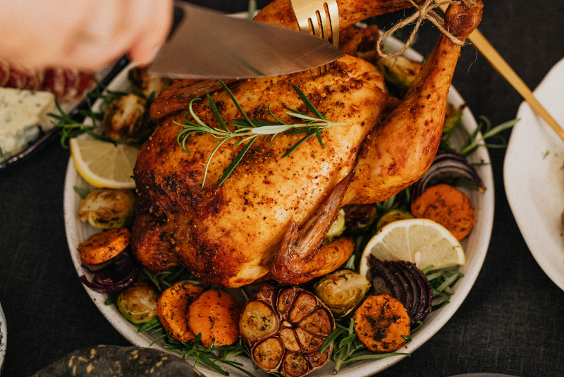 A Rotisserie chicken in a dish with vegetables and cutting knife at the Wentworth Inn.