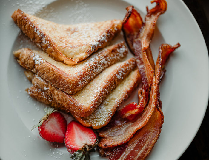 Powdered French toast with bacon and strawberries on a plate at the Wentworth