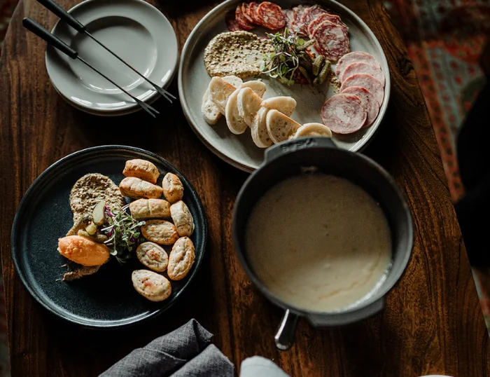 Soup, meats, and vegetables in bowls and plates on a table at the Wentworth