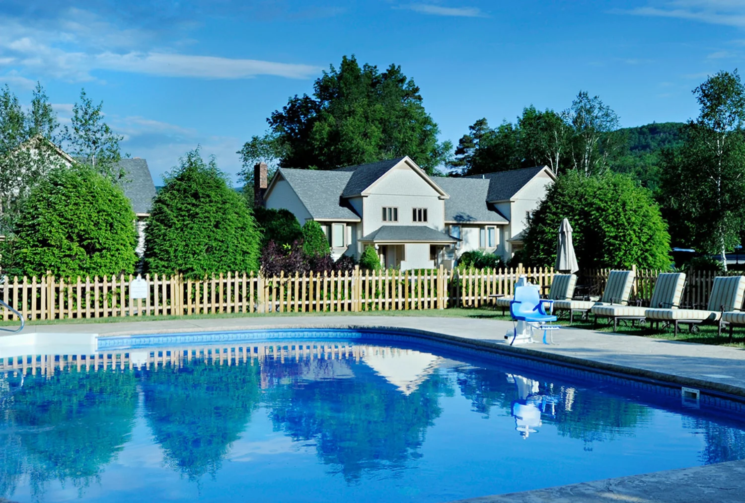 An outdoor pool with chairs and houses in the background at the Wentworth.