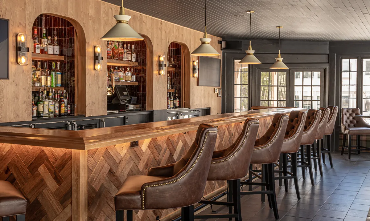 a bar with brown leather chairs and tables at the Wentworth.