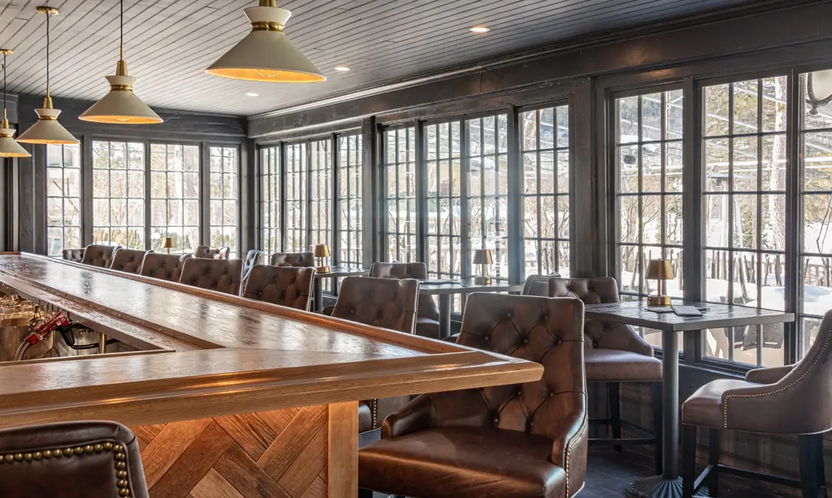 a bar with brown leather chairs at tables at the Wentworth.