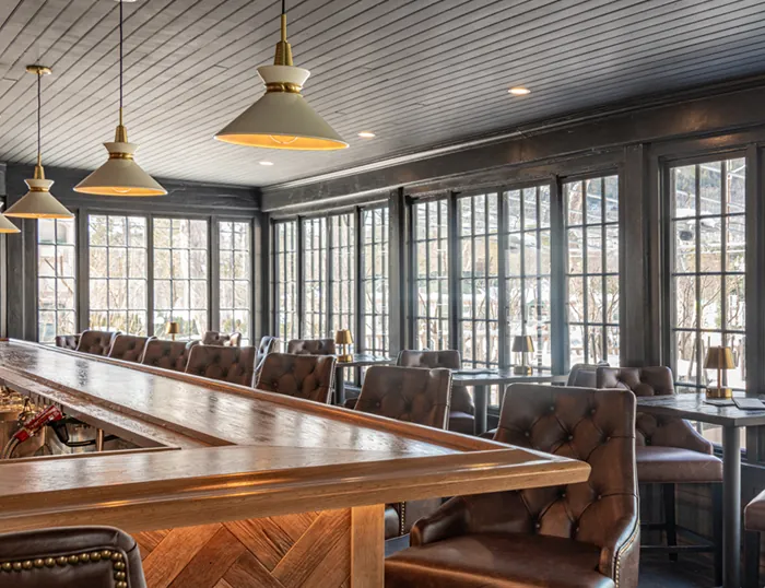 a bar with brown leather chairs at tables at the Wentworth.